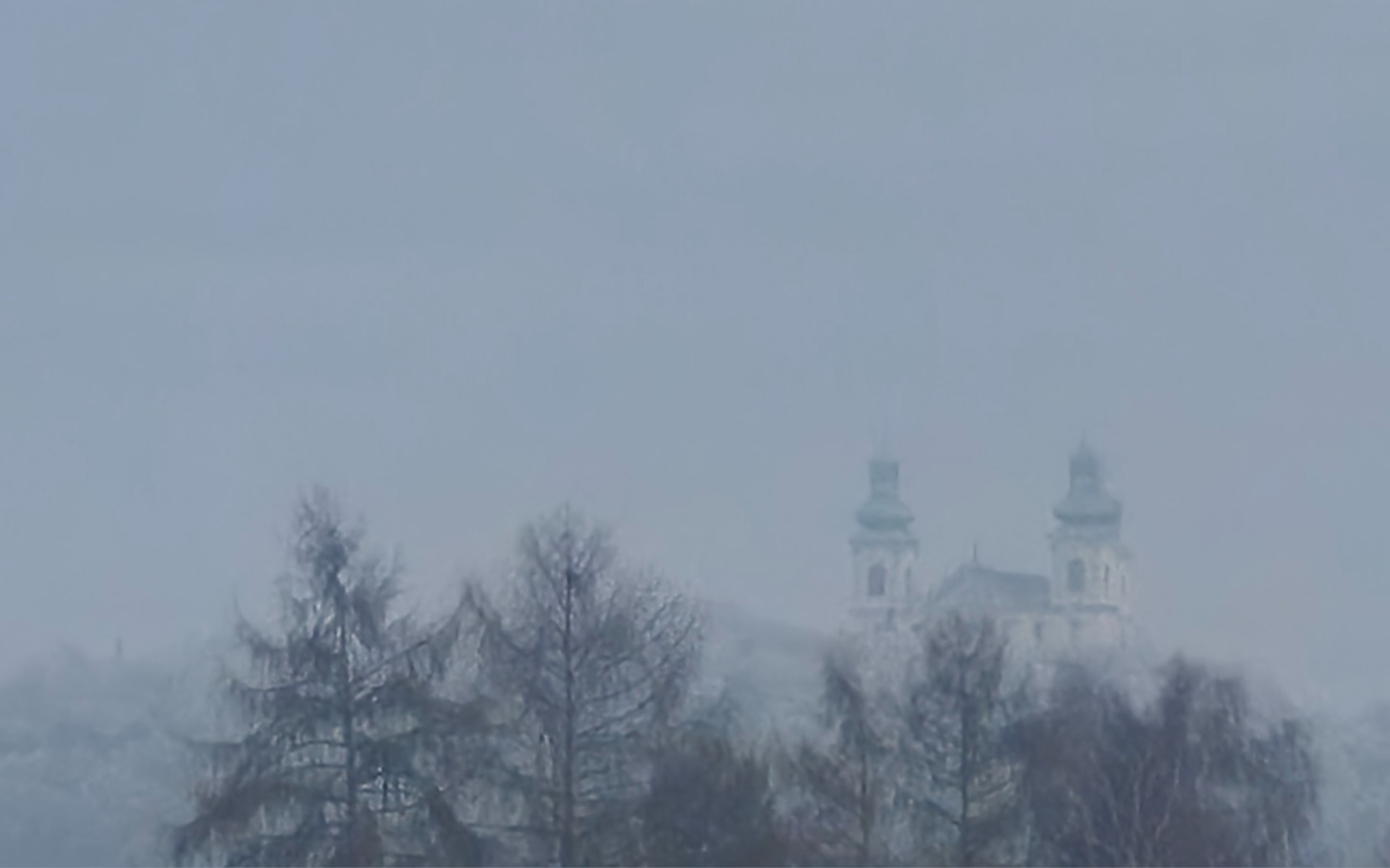 
        Zamglony widok na kościół w oddali.
    