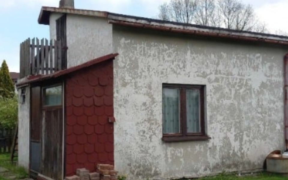 
        Stary dom z zewnętrzną ścianą w złym stanie.
    