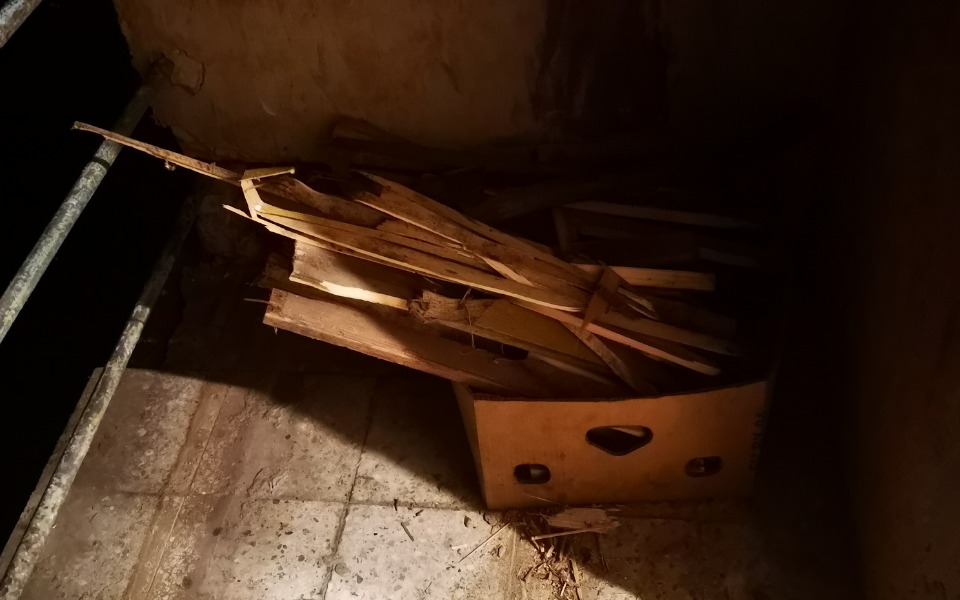 
        Stos drewnianych desek w kartonie na podłodze.
    