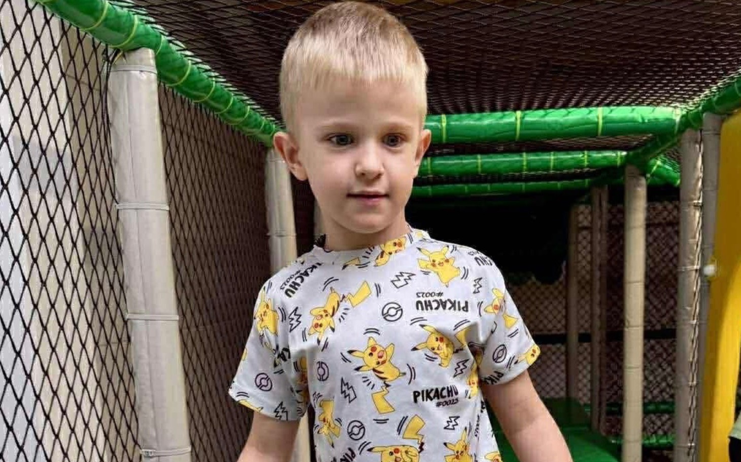 
        Chłopiec w koszulce z Pikachu bawiący się w placu zabaw.
    