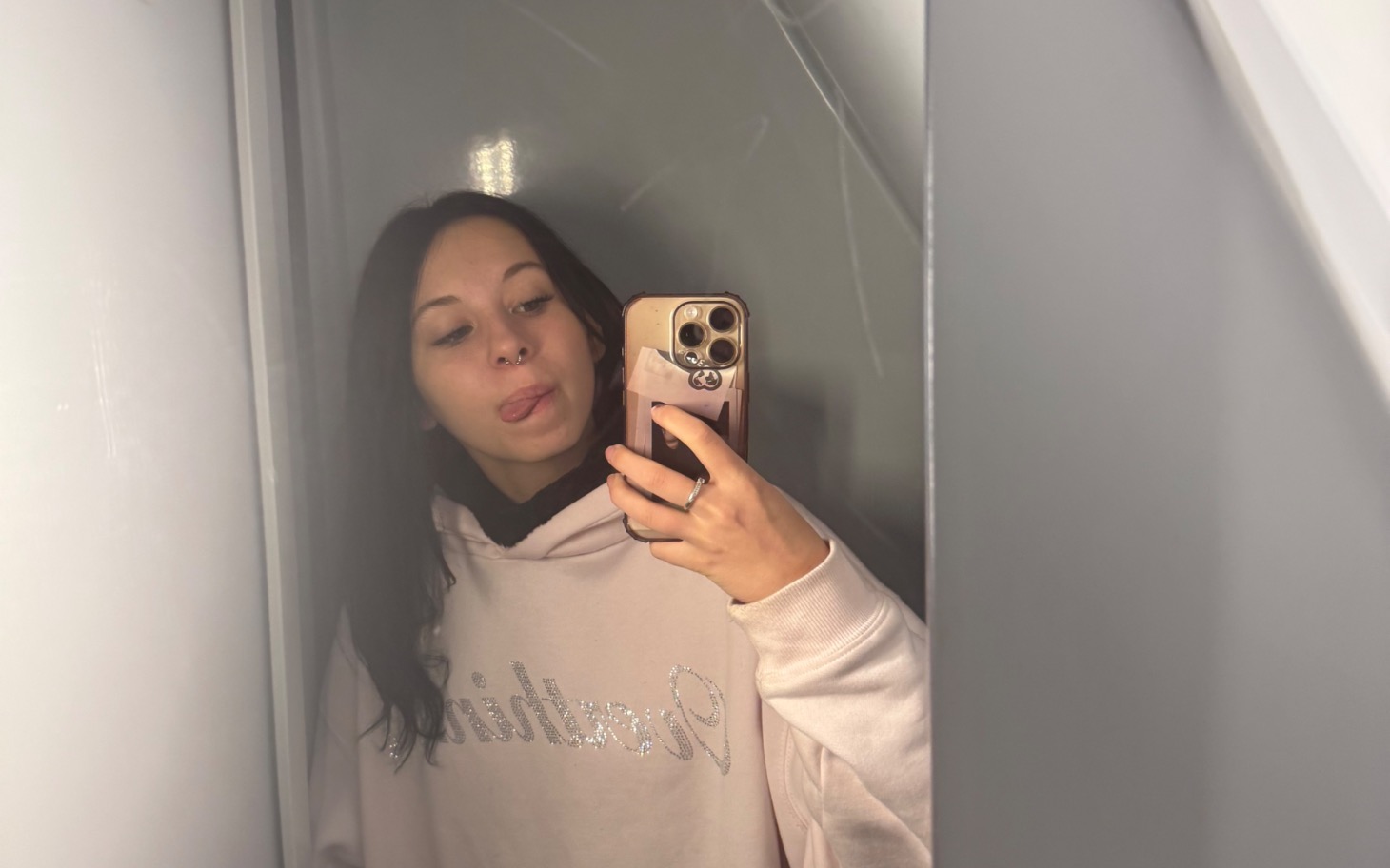 
        Młoda kobieta robiąca selfie w lustrze, pokazująca język.
    