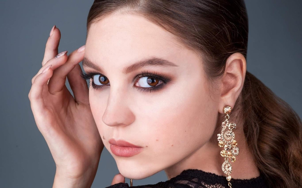 
        Portret dziewczyny z makijażem i biżuterią.
    