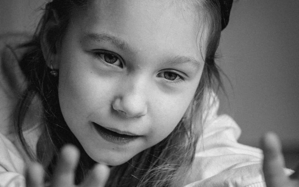 
        Portret małej dziewczynki z wyrazem twarzy pełnym ciekawości.
    