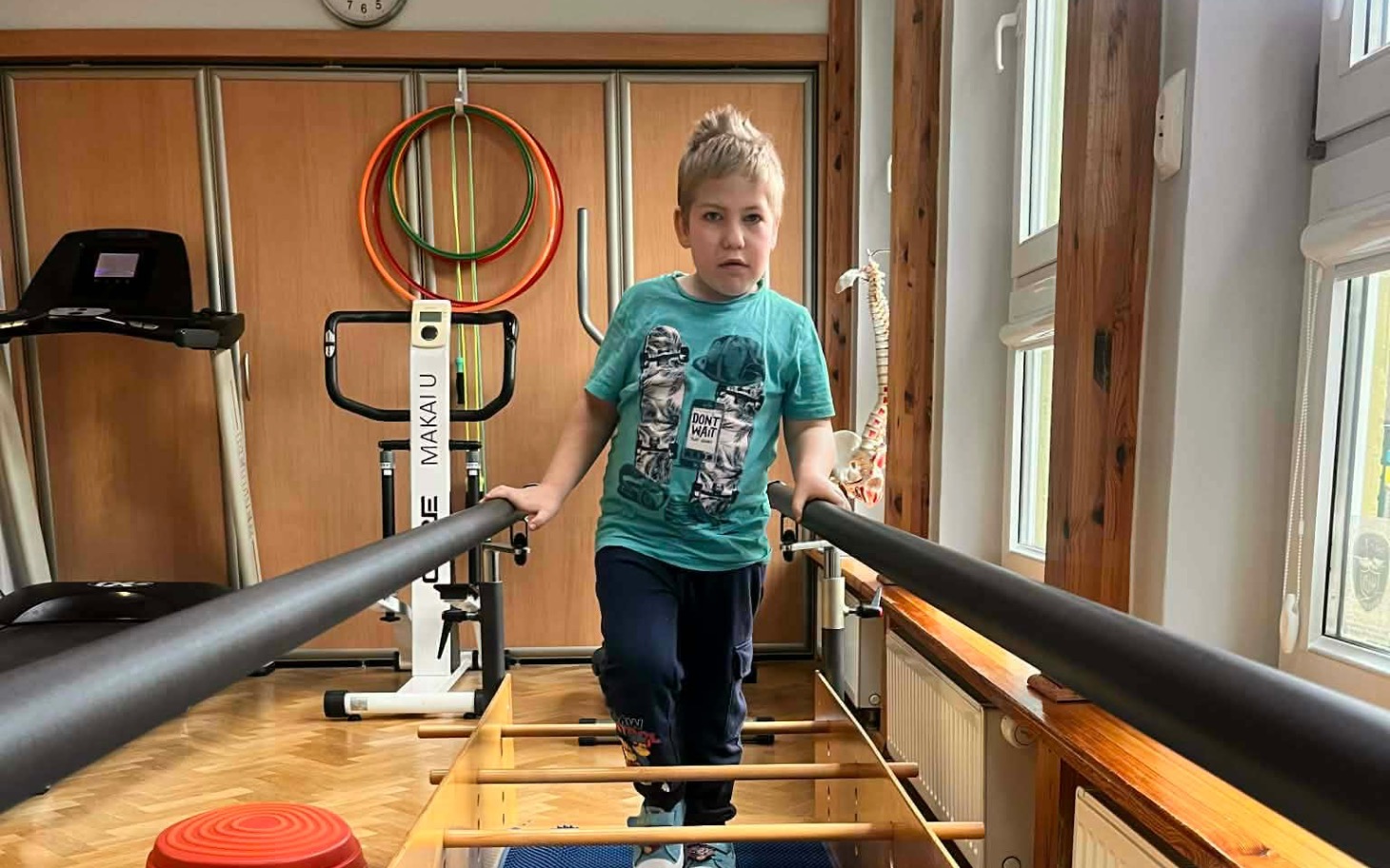 
        Chłopiec ćwiczący na sprzęcie rehabilitacyjnym.
    