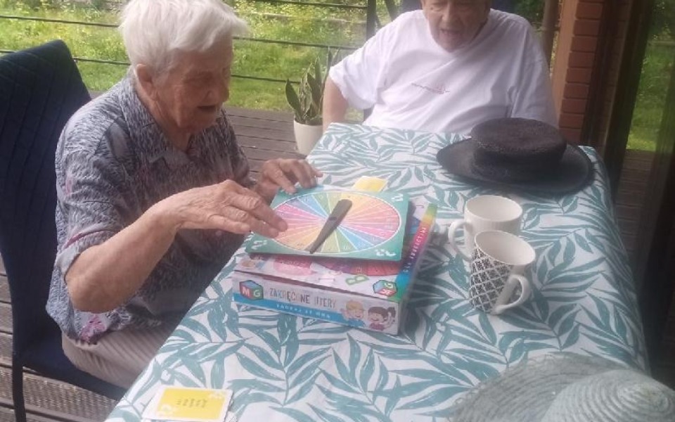 
        Dwie starsze kobiety grające w grę planszową na tarasie.
    