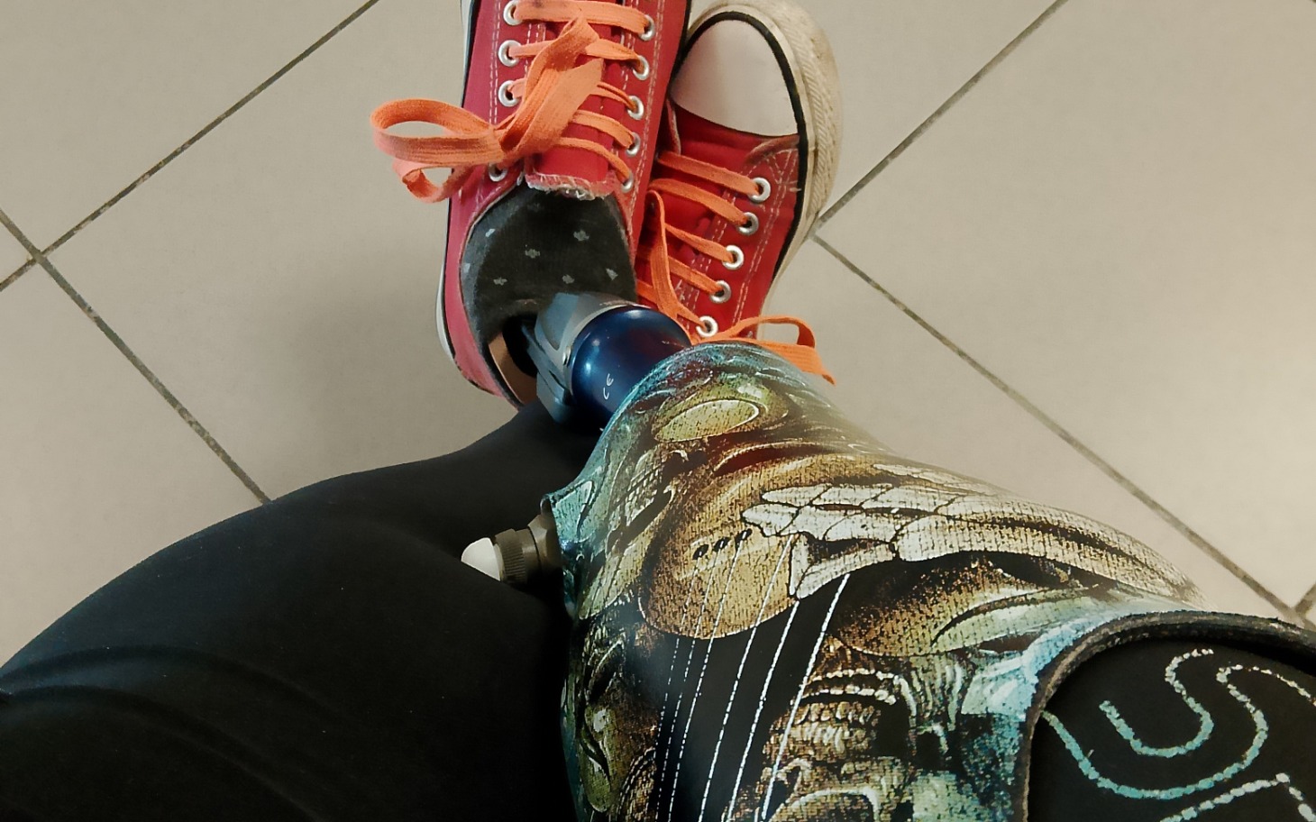 
        Osoba z protezą nogi w kolorowych butach.
    