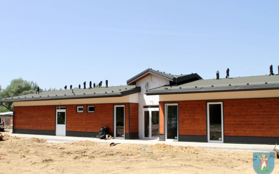 
        Nowoczesny budynek z drewnianą elewacją w otoczeniu natury.
    