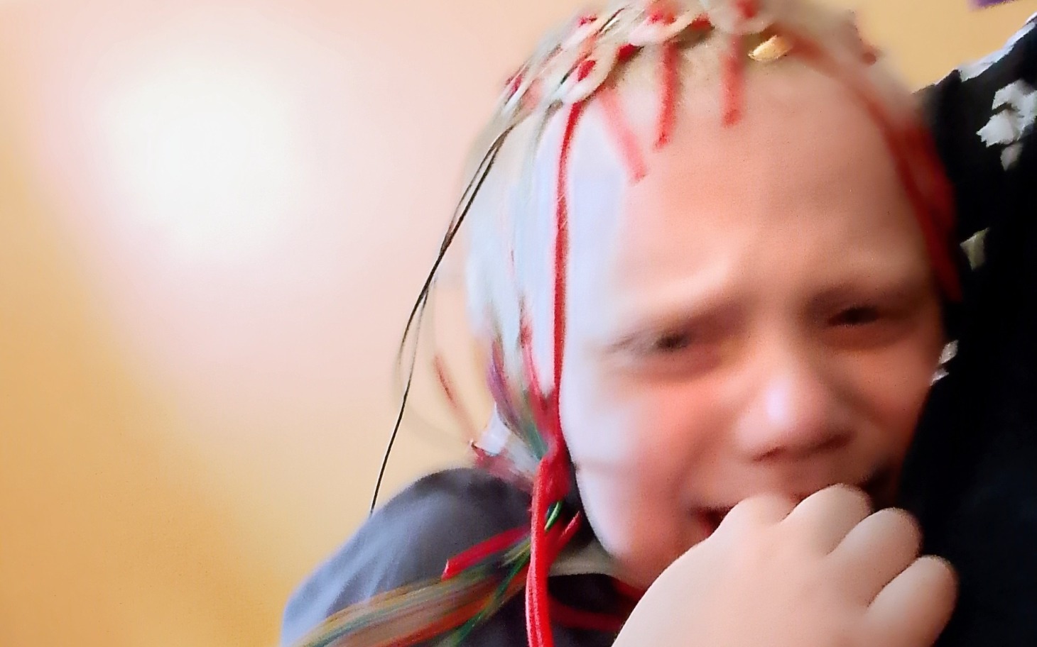 
        Chłopiec z płaczem, z ozdobami na głowie.
    