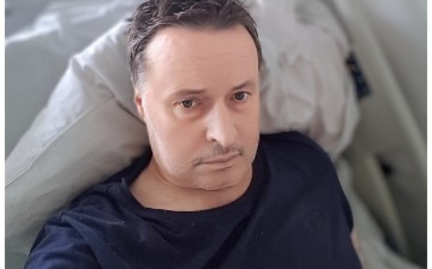 
        Mężczyzna w selfie na tle szarego, nowoczesnego wnętrza
    