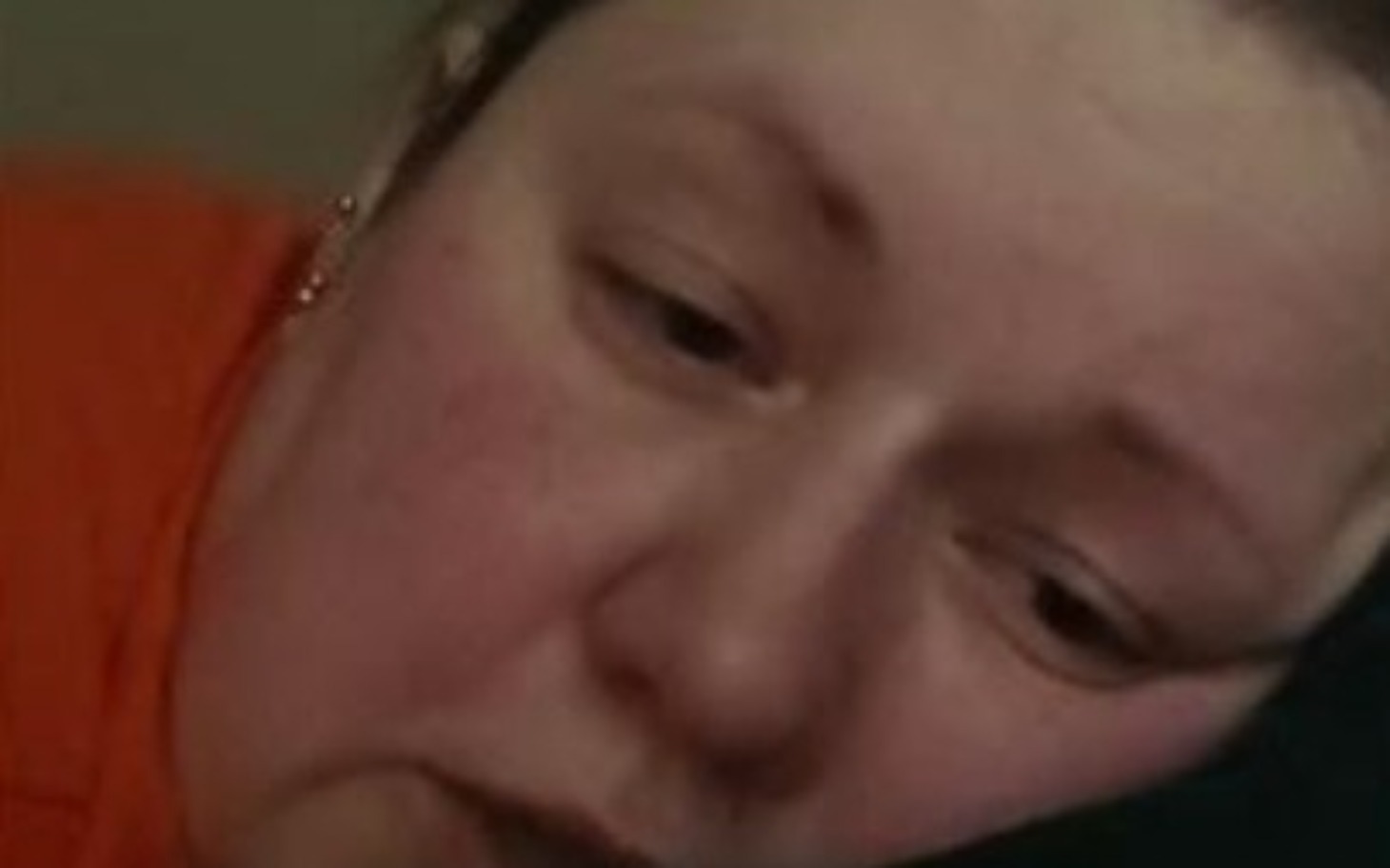 
        Kobieta leżąca na poduszce, z wyrazem zmartwienia.
    