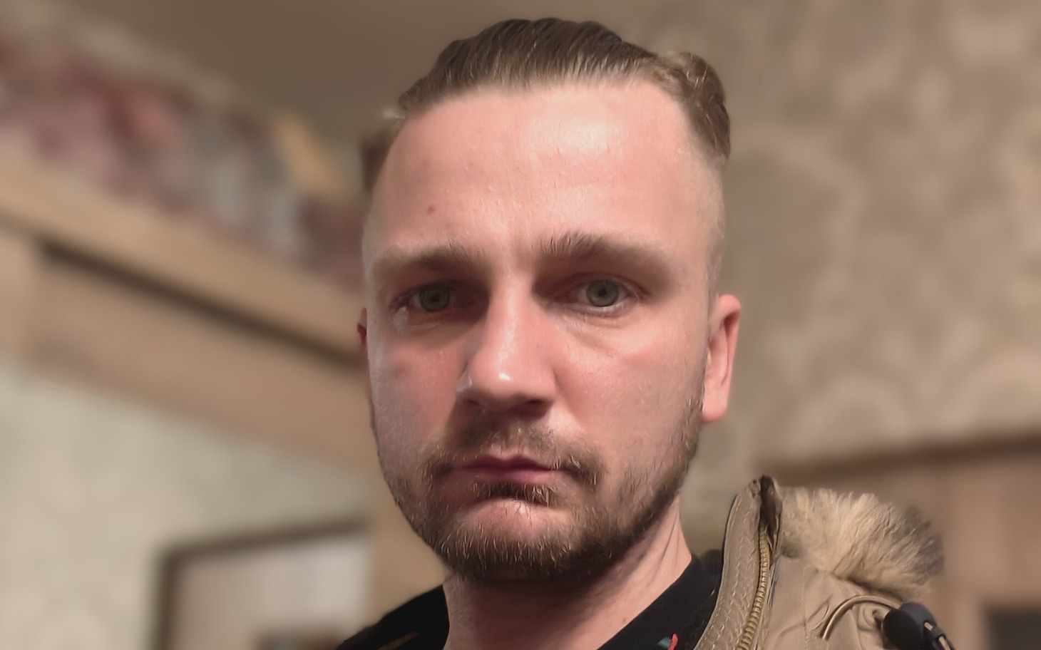 
        Mężczyzna z krótkimi włosami, patrzący w kamerę.
    