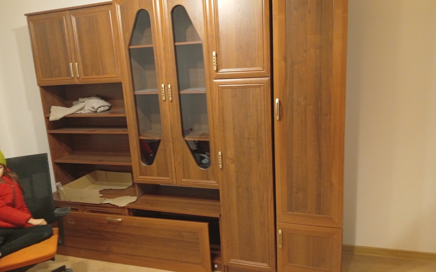 
        Meble w pokoju, w tym szafa i regał.
    