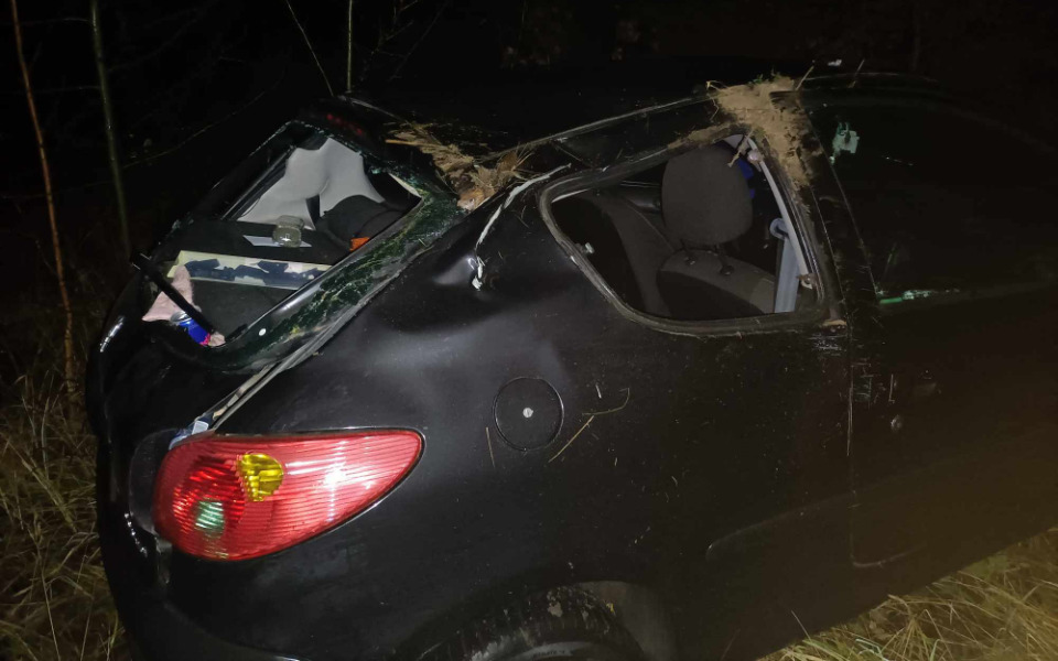 
        Zniszczony samochód w lesie po wypadku.
    