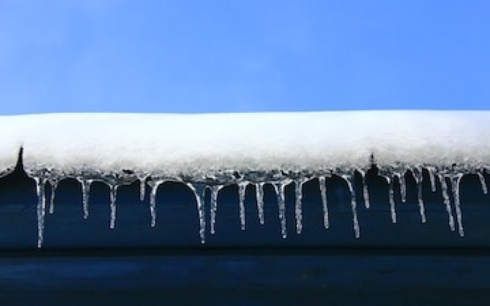 
        Sople lodu zwisające z dachu pokrytego śniegiem.
    