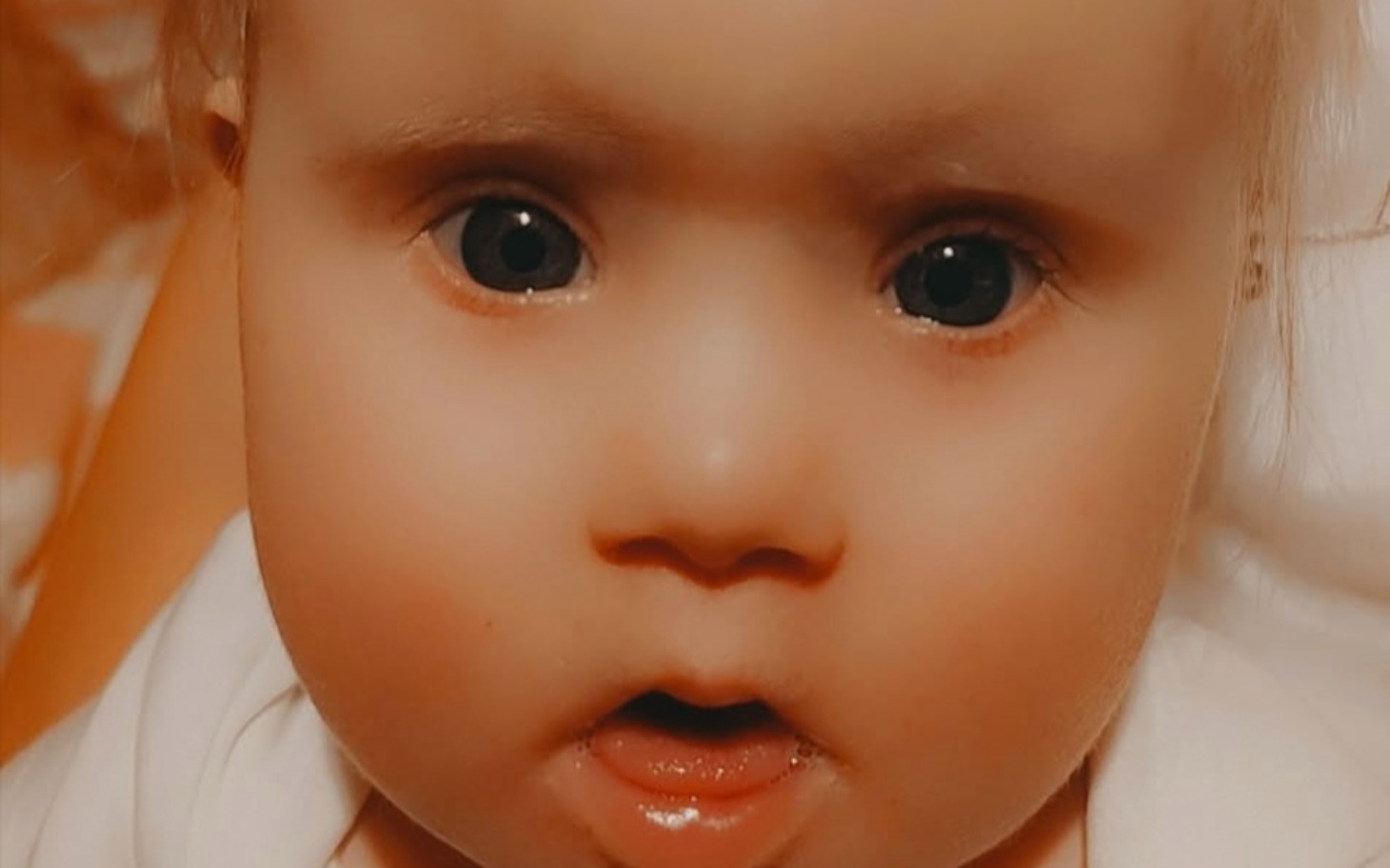 
        Urocza twarz niemowlęcia z dużymi oczami.
    