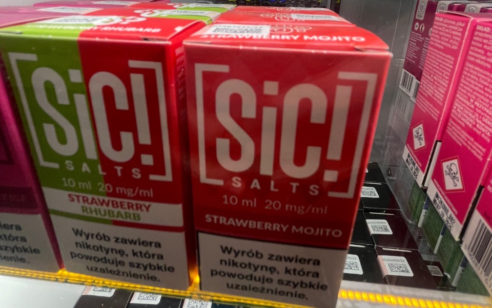 
        Opakowania e-liquidu o różnych smakach, w tym truskawkowym i rabarbarowym.
    