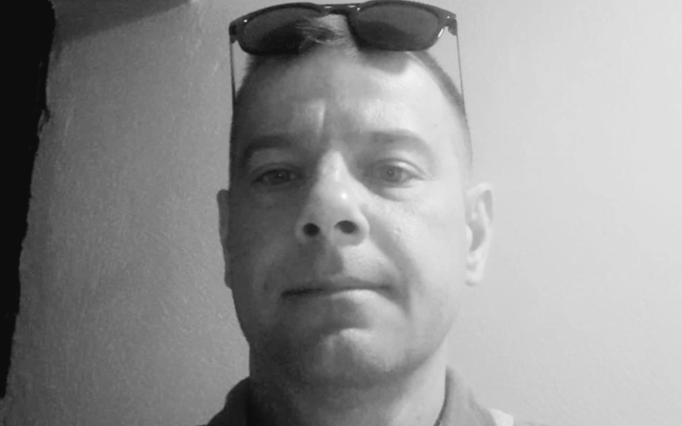 
        Mężczyzna w okularach przeciwsłonecznych, pozujący do zdjęcia.
    