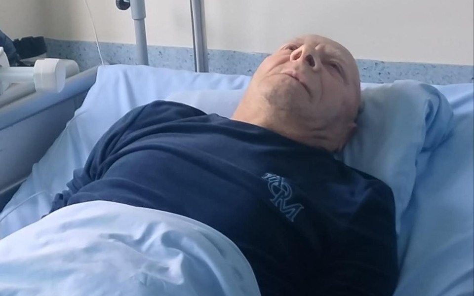 
        Mężczyzna leżący w szpitalnym łóżku, wygląda na zmartwionego.
    