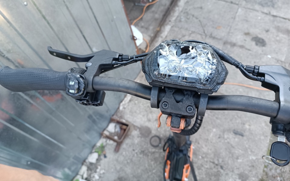 
        Uszkodzony rower elektryczny, widok na kierownicę.
    