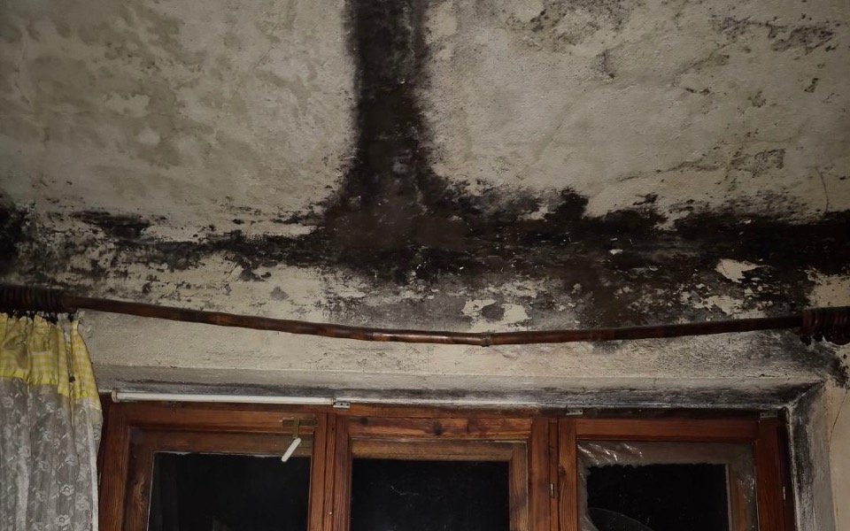 
        Zawilgocony sufit w pomieszczeniu, z widocznymi plamami pleśni.
    