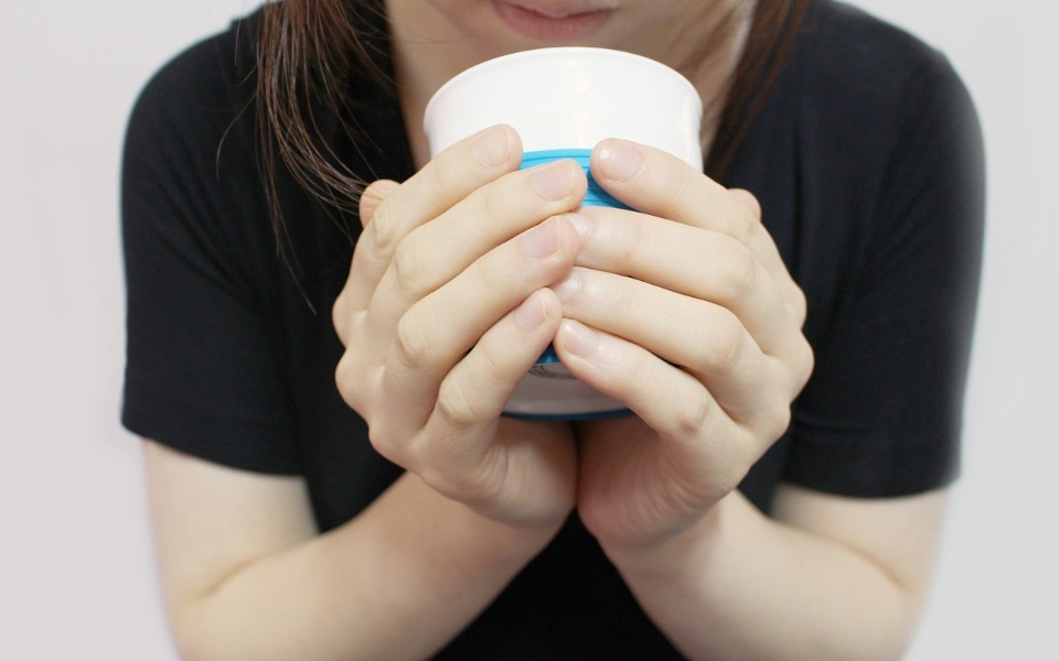 
        Osoba trzymająca kubek, ciesząca się chwilą relaksu.
    