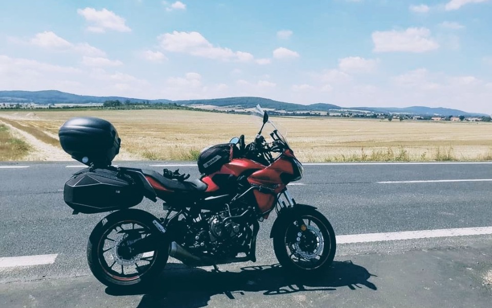 
        Motocykl na tle malowniczych pól, idealny na letnią przejażdżkę.
    