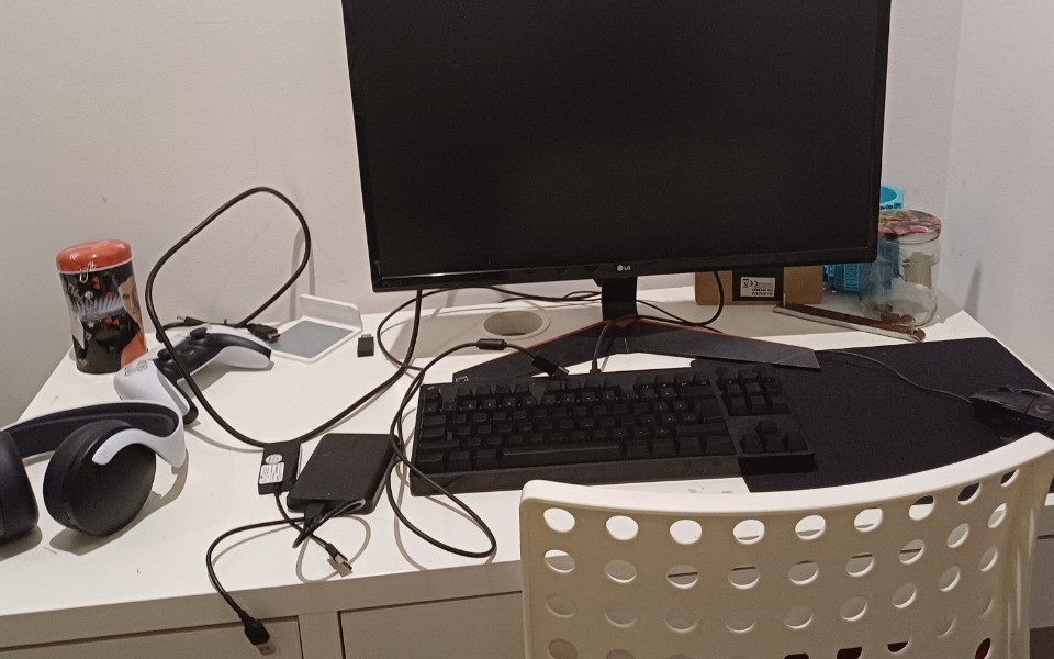 
        Zabałaganione biurko z komputerem i akcesoriami.
    