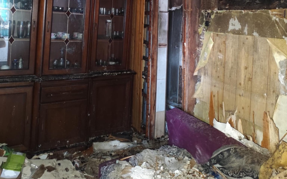 
        Zniszczone wnętrze po pożarze, z bałaganem.
    