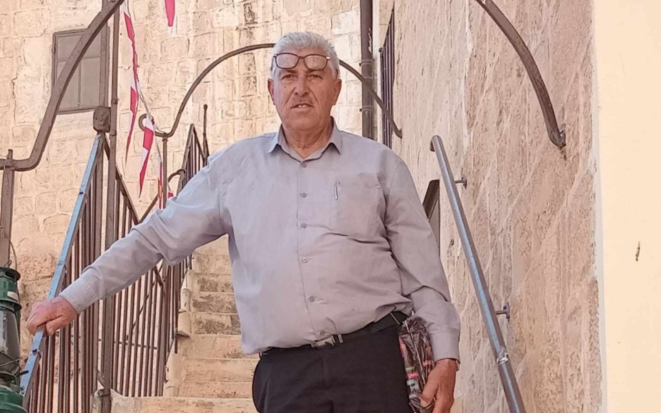 
        Starszy mężczyzna na schodach, z okularami, w uśmiechu.
    