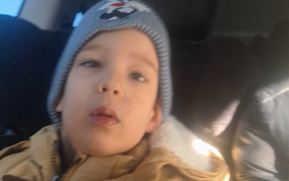 
        Mały chłopiec w czapce, z zamyślonym wyrazem twarzy.
    