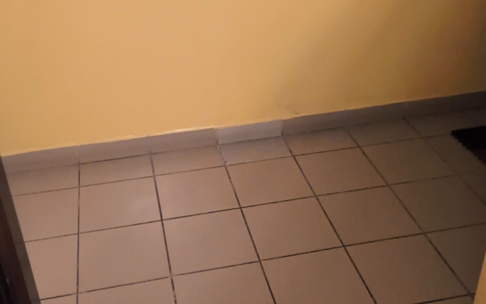 
        Pusty pokój z żółtymi ścianami i kafelkami na podłodze.
    