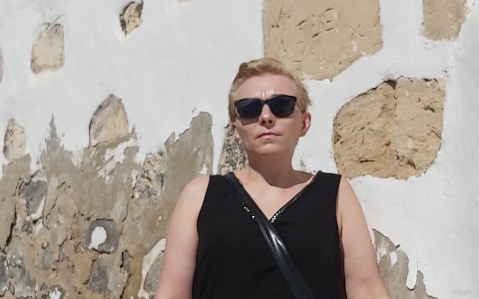 
        Kobieta w czarnym topie i okularach przeciwsłonecznych.
    