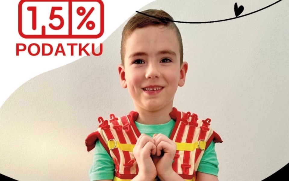 
        Chłopiec w kamizelce ratunkowej, uśmiechający się do kamery.
    