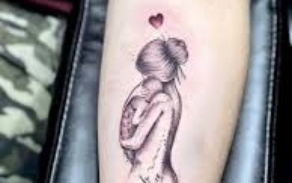 
        Tatuaż przedstawiający matkę z dzieckiem i sercem nad nimi.
    