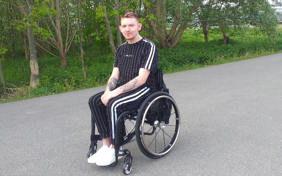 
        Mężczyzna na wózku inwalidzkim, ubrany w sportowy strój.
    