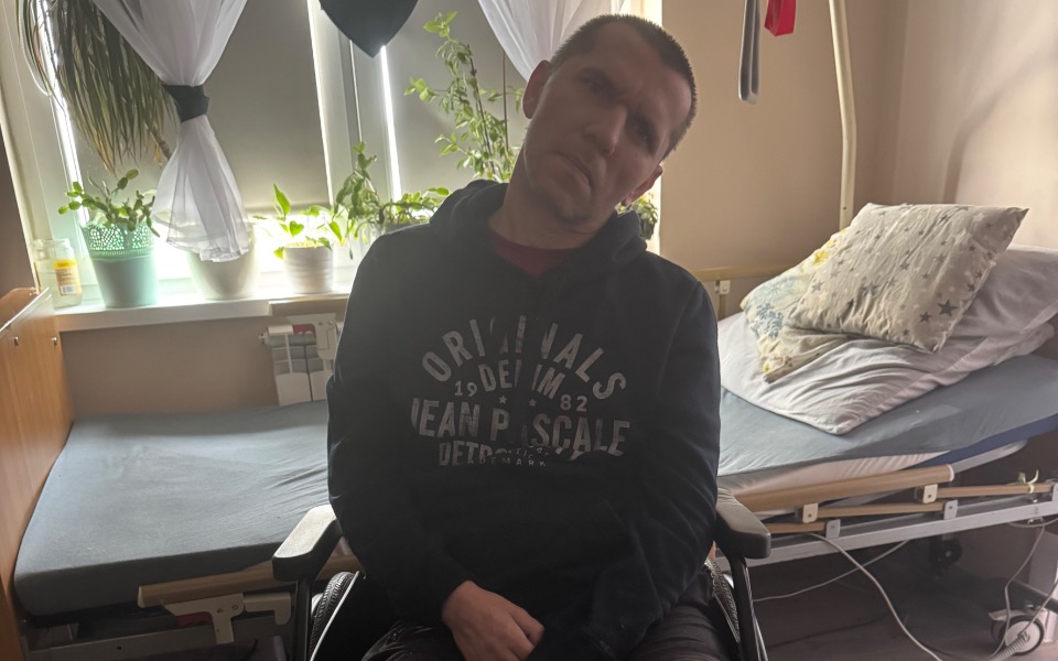 
        Mężczyzna na wózku inwalidzkim w pokoju.
    