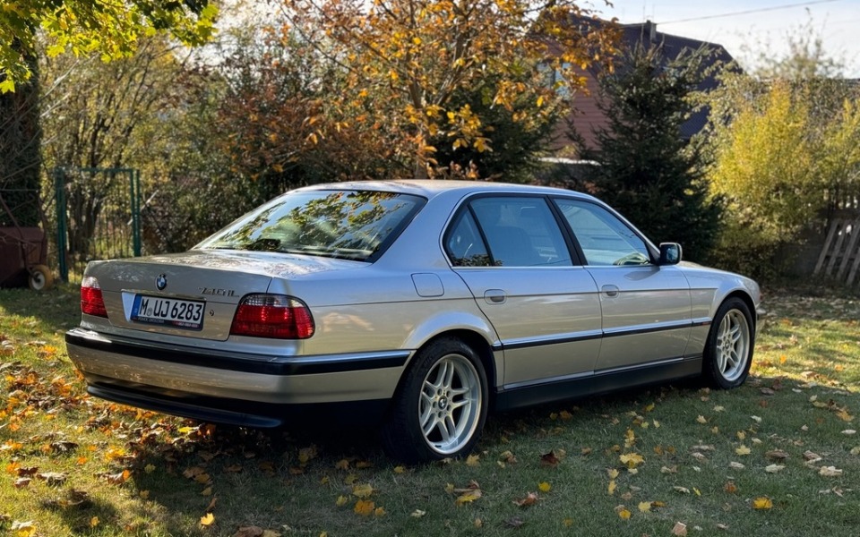
        Samochód BMW zaparkowany wśród opadłych liści.
    