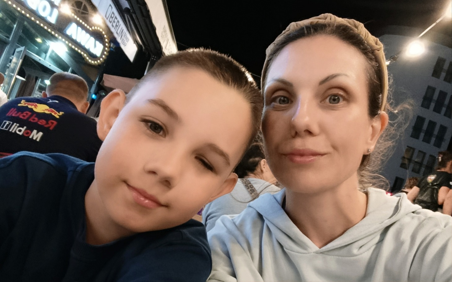 
        Mama z synem w kawiarni, uśmiechnięci i zrelaksowani.
    