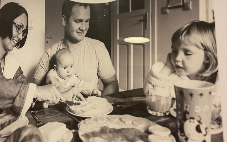 Rodzina przy stole, jedząca posiłek z dzieckiem.