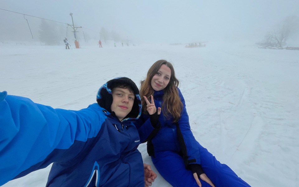 
        Młoda para na stoku narciarskim, ciesząca się zimą.
    