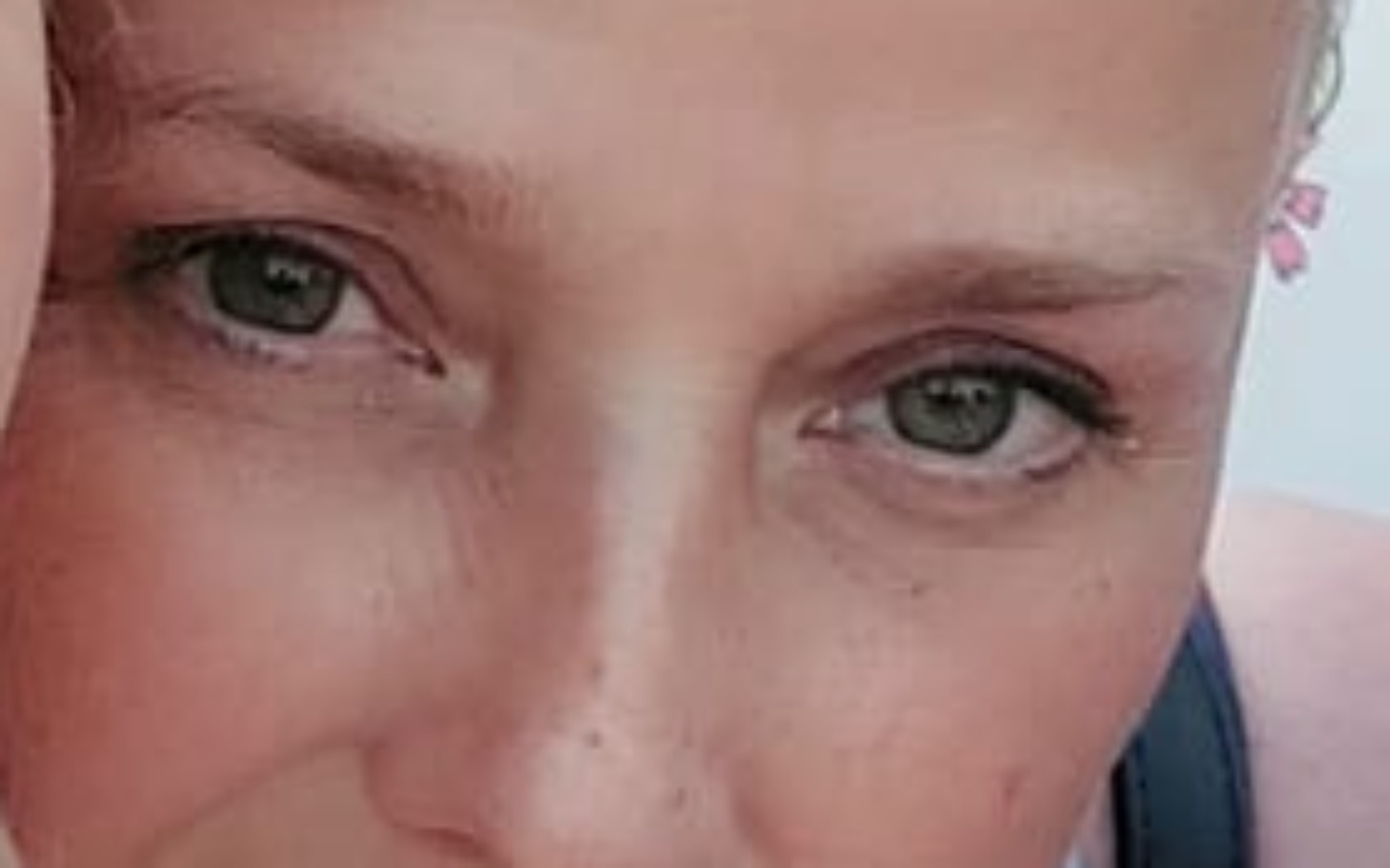 
        Zbliżenie na twarz kobiety z kwiatkiem we włosach.
    