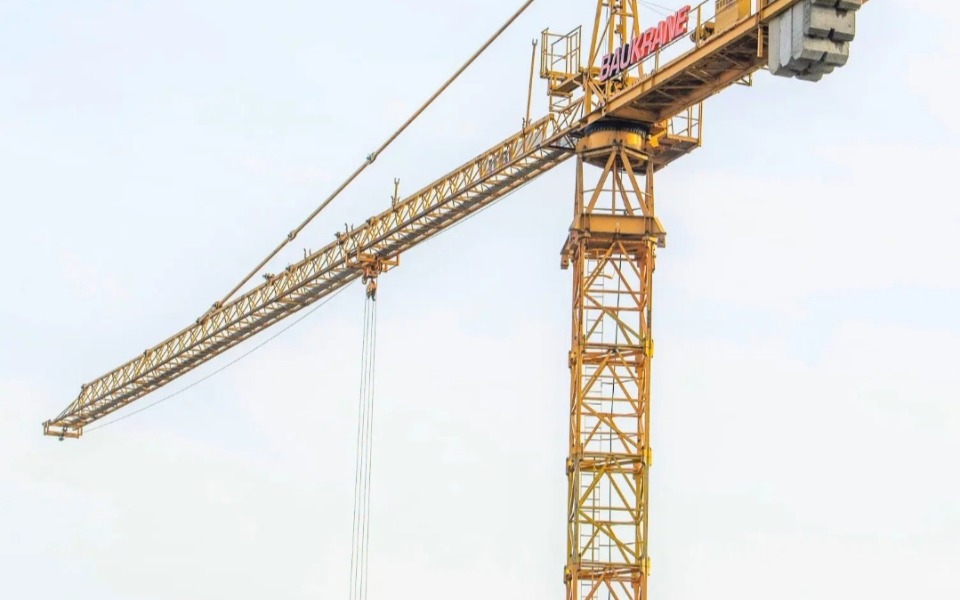 
        Żółty dźwig budowlany na tle nieba.
    