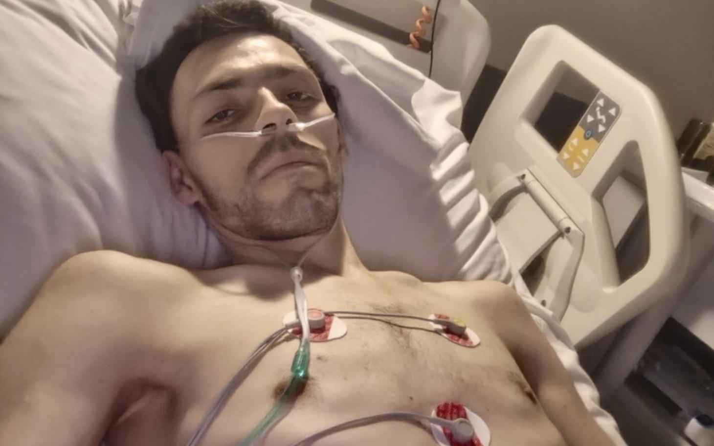 
        Mężczyzna leżący w szpitalu, podłączony do monitorów.
    