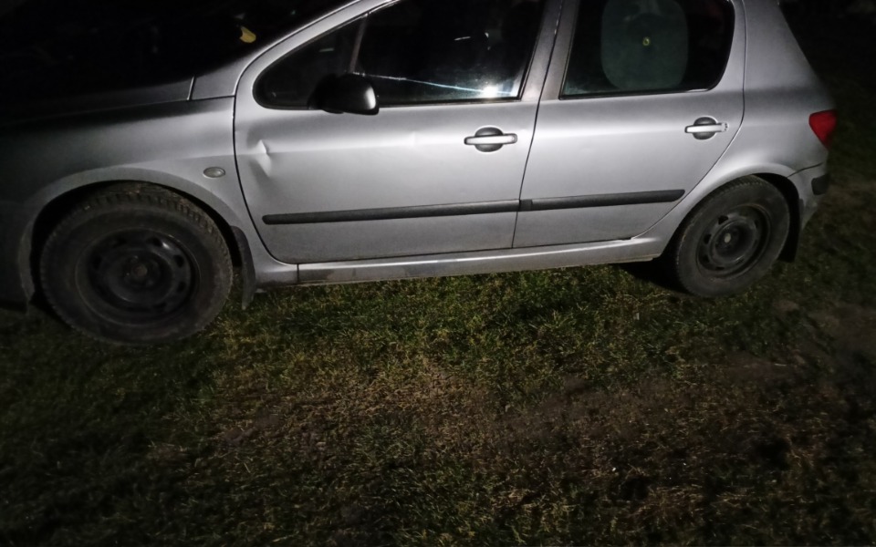 
        Samochód zaparkowany na trawie, z widocznymi oponami.
    