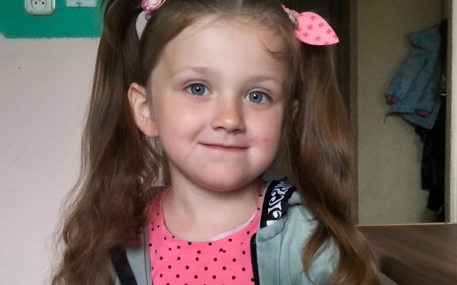 
        Dziewczynka z długimi włosami, uśmiechająca się w różowej bluzce.
    