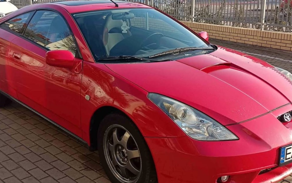 
        Czerwony samochód sportowy zaparkowany na ulicy.
    