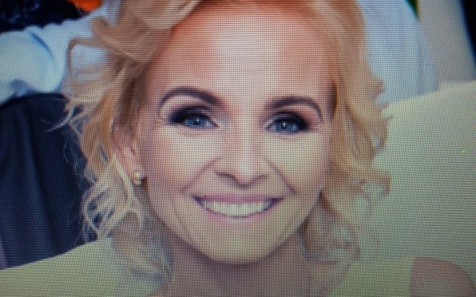 
        Uśmiechnięta kobieta z blond włosami na zdjęciu portretowym.
    