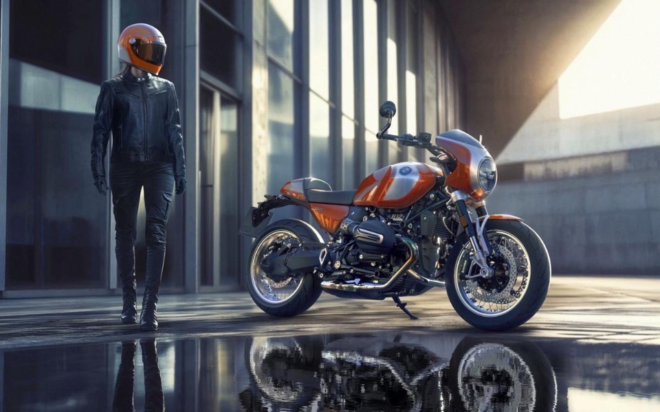 
        Motocykl w nowoczesnym otoczeniu, obok stoi motocyklista.
    