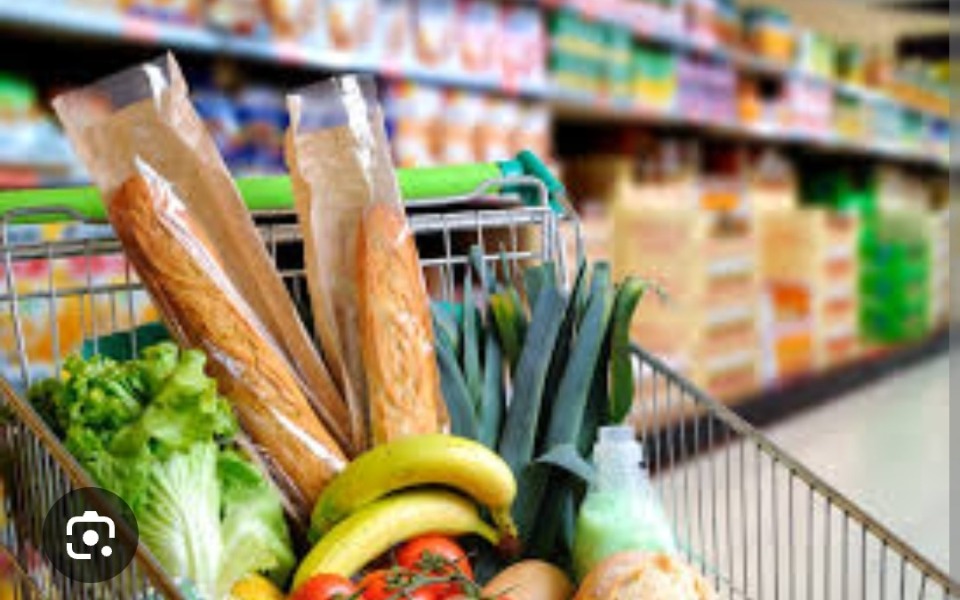 
        Koszyk zakupowy wypełniony świeżymi warzywami i pieczywem.
    