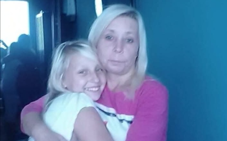 
        Kobieta przytula dziewczynkę, obie uśmiechają się do kamery.
    